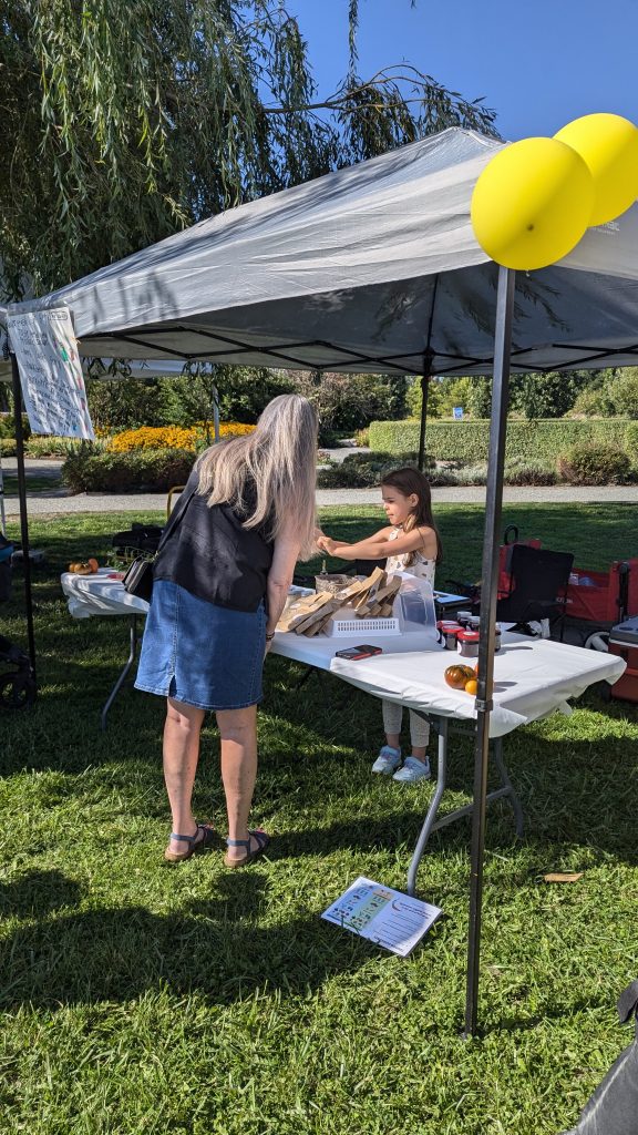 Adair helping a customer at her first market